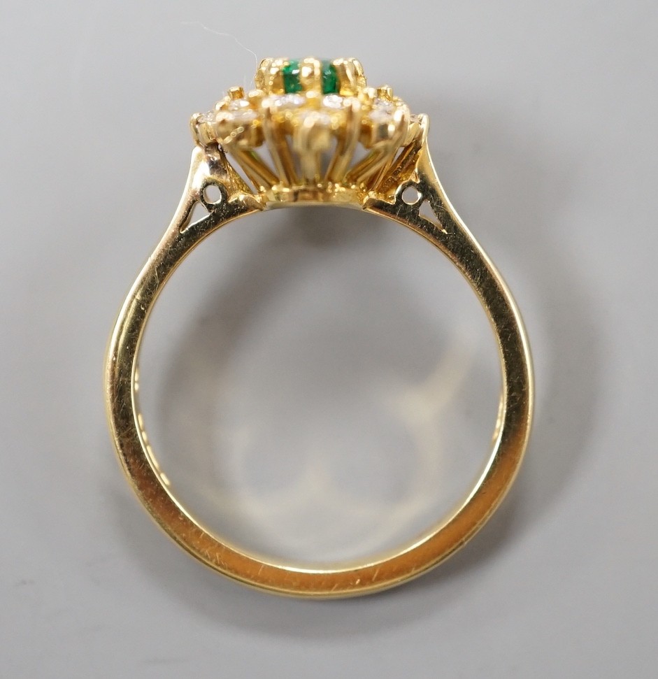 A modern 18ct gold, emerald and diamond set star shaped cluster ring, size L/M, gross weight 3.8 grams